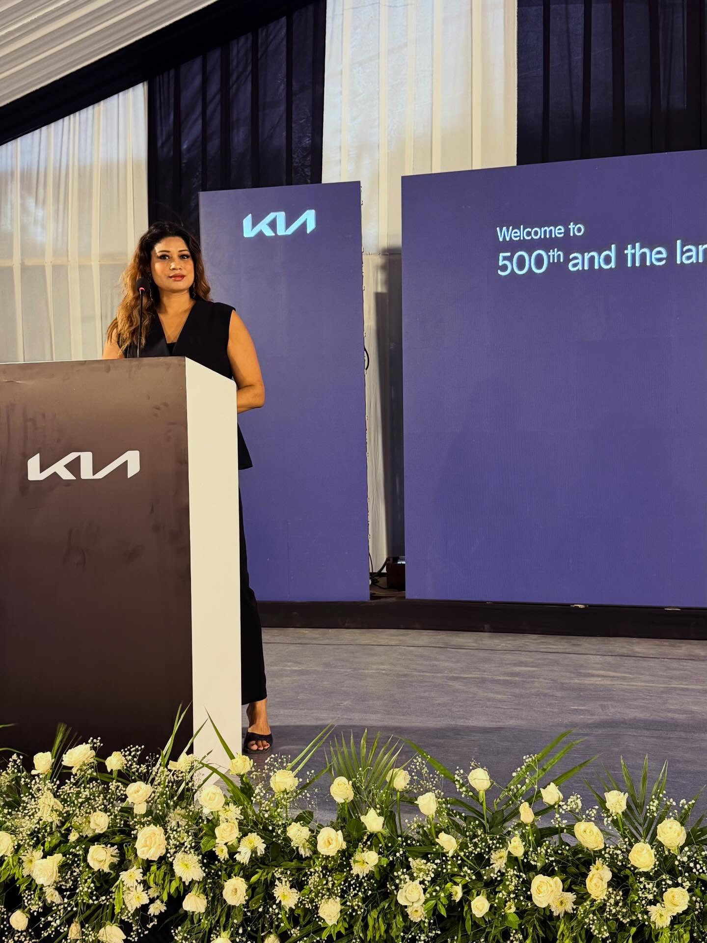 Monica Singh at the podium for a Kia dealership launch